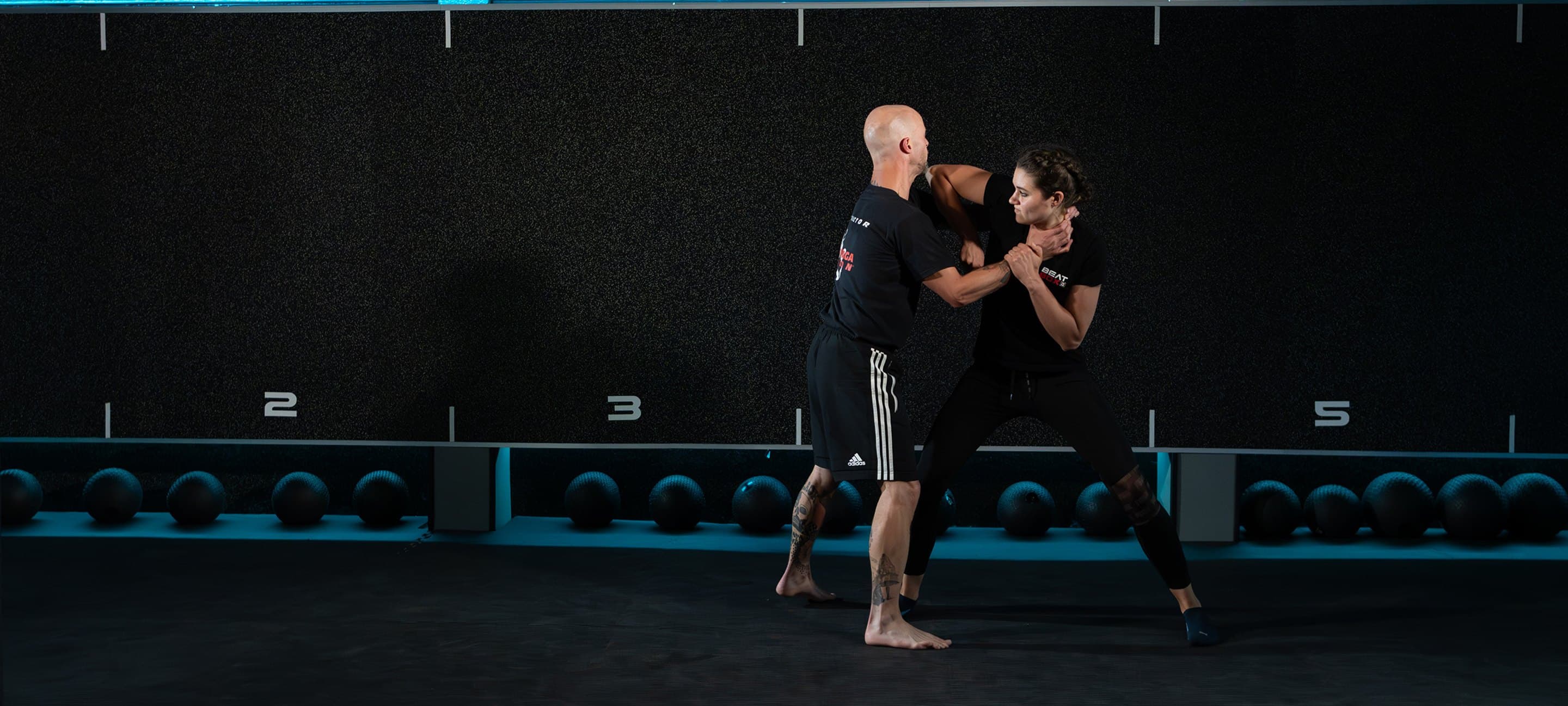 Männer und Frauen trainieren Krav Maga in einer Turnhalle